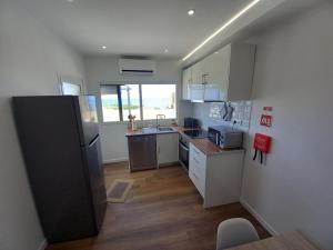 a small kitchen with a refrigerator and a sink at Alto do Sossego in Nordeste