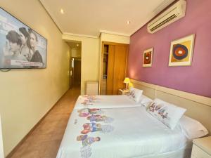 2 Betten in einem Zimmer mit lila Wänden in der Unterkunft Luz Madrid Rooms in Madrid + 42 Fotos