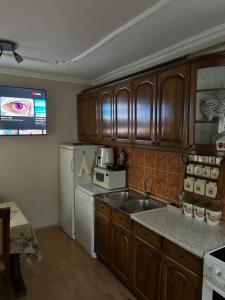 Una cocina con fregadero y refrigerador blanco. en Apartment White, en Bijela