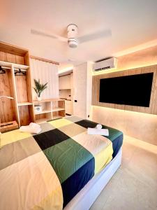 Un dormitorio con una cama colorida y un televisor de pantalla plana. en SUITE PLAYA CARIHUELA Apartamentos, en Torremolinos 16 fotos más
