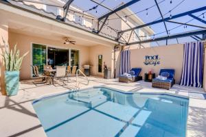 einen Pool auf einer Terrasse mit einem Tisch und Stühlen in der Unterkunft Luxury Family Villa 4 BR & Pool & BBQ at Solterra Resort in Davenport