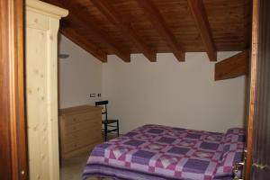 1 dormitorio con cama y techo de madera en Appartamento Pommier, en Saint-Pierre