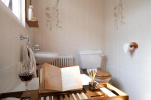 a table with a book and a glass of wine at Stratford Green House in London