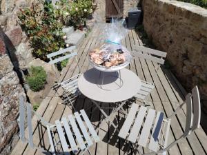 a grill on a table with chairs on a patio at Chez Adèle, au pied de l'Abbaye in Le Mont Saint Michel