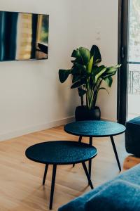 two tables in a living room with a potted plant at Dreamy Glyfada Apartment in Athens