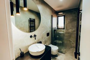 a bathroom with a sink and a toilet and a mirror at Dreamy Glyfada Apartment in Athens +20 photos
