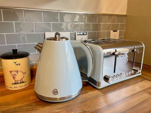 einen Toaster und eine Kaffeekanne auf einer Küchentheke in der Unterkunft Miners cottage(1840)Nr. Brecon,Tower Zip & Bike Pk in Aberdare