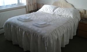 a bed with white sheets and towels on it at Gilesgate Moor Hotel in Durham