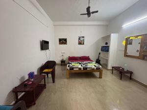 KuilapayamSanchari hostel的一间有床、沙发和桌子的房间