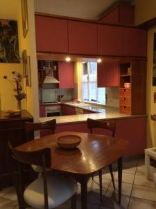 a kitchen with a wooden table with chairs and a counter at Oasi La Francoise in Rozzano +8 photos