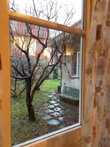 a window with a view of a tree and a bench at Oasi La Francoise in Rozzano