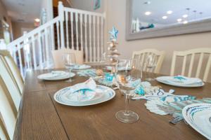 ein Esstisch mit Tellern und Weingläsern in der Unterkunft Luxury Family Villa 4 BR & Pool & BBQ at Solterra Resort in Davenport