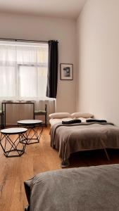 een slaapkamer met 2 bedden en 2 tafels bij Central premium apartment in München
