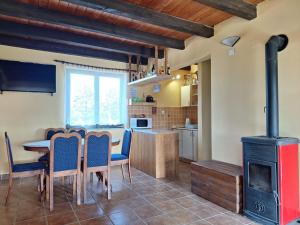 a kitchen and dining room with a wood stove at Mirni raj in Zlatar