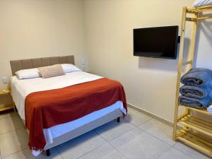 a bedroom with a bed and a flat screen tv at Flat 01 Quarto e sala novo na rua dos Girassóis em Bonito-PE in Bonito