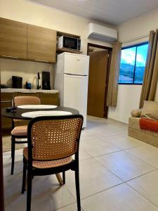 a kitchen with a table and chairs and a refrigerator at Flat 01 Quarto e sala novíssimo na rua dos Girassóis em Bonito in Bonito