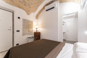 a bedroom with a bed in a white room at Rooms in the Old town in Termoli