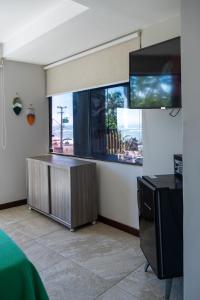 a room with a fish tank and a tv at Pousada Makai in Porto De Galinhas