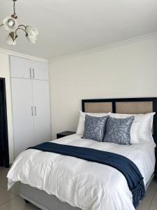 a bedroom with a large bed with blue and white pillows at Elyon Suites in Kempton Park