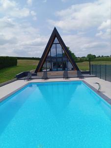 a swimming pool with a pyramid shaped building at Villa Rustic 