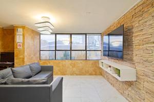 a living room with a couch and a brick wall at 5 Bedroom - 1 Block from Lleras - P2 in Medellín