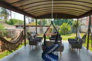 a group of hammocks hanging from a pergola at Casa Modernista - Aluguel de Suítes in Brasilia