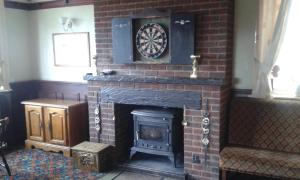 a brick fireplace with a dartboard on top of it at Gilesgate Moor Hotel in Durham