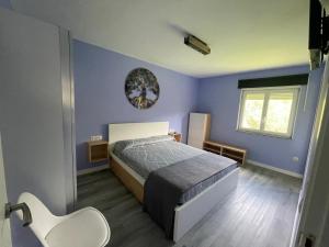 a blue bedroom with a bed and a window at La Caleya de Ozanes 