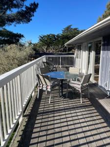 a patio with a table and chairs on a deck at Elegant Carmel Cottage in Carmel