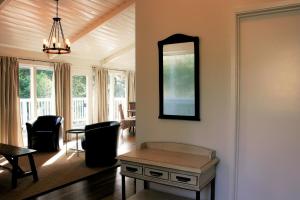 a living room with a table and a mirror at Elegant Carmel Cottage in Carmel