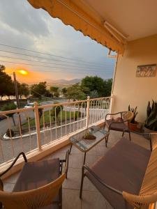 a balcony with chairs and a table and a sunset at Neraida view in Neráïdha
