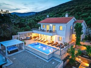 an aerial view of a house with a swimming pool at Villa St Martin-Reef - Exclusive Seafront Villa with Private Heated Pool in Martinšćica