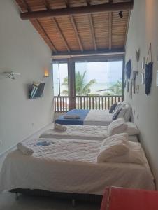 a row of beds in a room with a window at Pousada Makai in Porto De Galinhas +40 photos