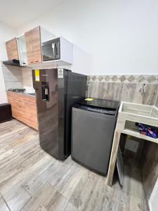 a kitchen with a black refrigerator and a counter at Meraki Urban Lofts in Quibdó