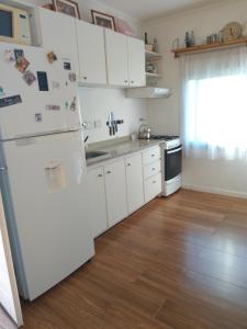 a kitchen with white appliances and a wooden floor at Bello atardecer Uribe in Uribelarrea +13 photos