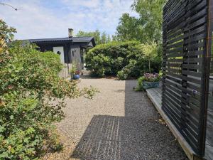 un jardín con un banco y algunos arbustos y una casa en 4 person holiday home in FARHULT-By Traum, en Farhult