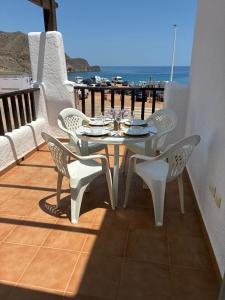 biały stół i krzesła na balkonie z widokiem na ocean w obiekcie Apartamento con vistas al mar en la Isleta del Moro w mieście Níjar