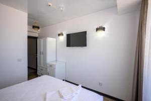 a bedroom with a bed and a tv on the wall at Miraky Beach in Văleni +14 photos