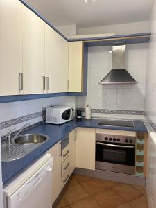 kuchnia z białymi szafkami, zlewem i kuchenką mikrofalową w obiekcie Apartamento con vistas al mar en la Isleta del Moro w mieście Níjar +14 zdjęć