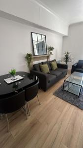 a living room with a black couch and a table at 2BR Apartment - LuxeSuites - City Centre in Midland