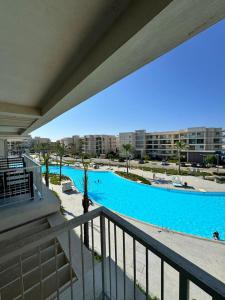 einen Balkon mit Blick auf einen großen Pool in der Unterkunft Apartment at Marassi in El-Alamein
