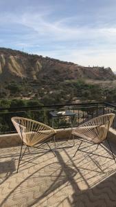 deux chaises et une table sur un balcon avec vue dans l'établissement L'Oasis del Maria Fatima, à Agadir nʼ Aït Sa
