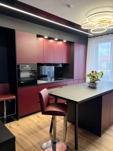 a kitchen with pink and purple cabinets and a table at Sapore Dream STUDIO 3 in Opole
