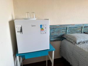 Habitación con nevera pequeña junto a la cama en Suíte Casa de Luz-Lar na Serra-Quarto 2, en Miguel Pereira