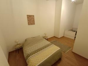 a small bedroom with a bed and two tables at Appartements de charme centre de Montpellier in Montpellier
