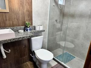 Un baño con inodoro y ducha de cristal. en Suíte Casa de Luz-Lar na Serra-Quarto 2, en Miguel Pereira 19 fotos más