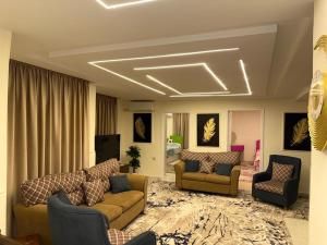 ein Wohnzimmer mit Sofas und Stühlen sowie einem TV in der Unterkunft شقة مفروشة للايجار اكتوبر حي اول in Madinat as-Sadis min Uktubar