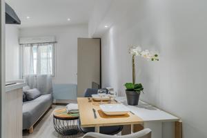 a living room with a table and a couch at Studio Confort - Proche Gare&Centre - Futuroscope 2 in Châtellerault