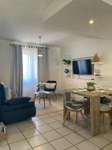 ein Wohnzimmer mit einem blauen Sofa und einem Tisch in der Unterkunft Nid douillet a la campagne in Saint-Jean-de-Bournay