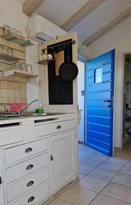 a kitchen with a white counter and a blue door at Charming apartment in Zambratija, 44 sqm, Parking included in Zambratija